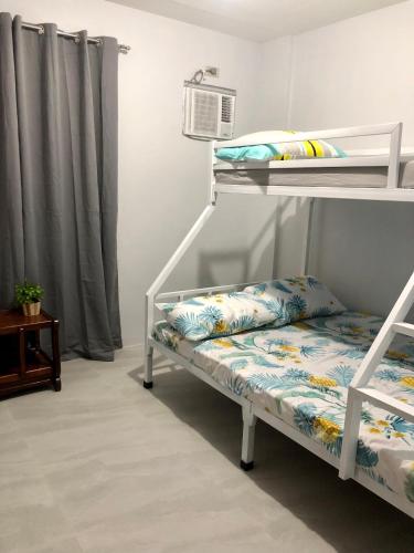 a white bunk bed with a pillow and a shelf at Sebastian’s Crib F in Dasmariñas