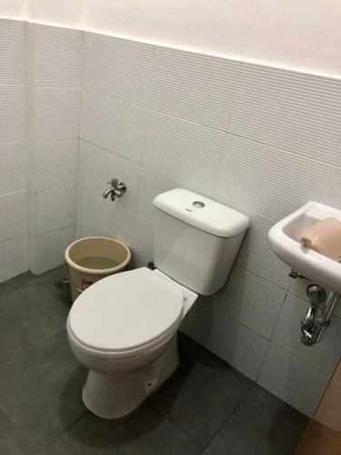 a bathroom with a white toilet and a sink at Sebastian’s Crib F in Dasmariñas