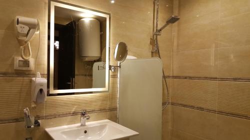 een badkamer met een wastafel, een spiegel en een douche bij Sheraton Ocean 202 - Private apartments in Caïro