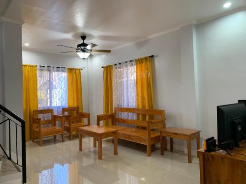 a living room with wooden benches and a tv at Entire Island home with Starlink and gated parking in Dapa