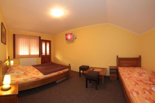a bedroom with two beds and a table and chairs at Pensiunea Elisabeta in Sovata