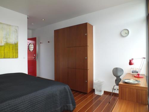 a bedroom with a bed and a wooden cabinet at Hotel CPH Living in Copenhagen