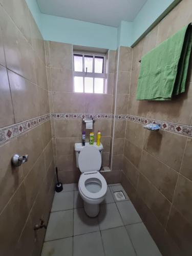 a bathroom with a toilet and a green towel at Lovely 1 bedroom with free speedy wifi in Nairobi