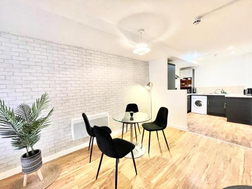 a living room with a table and chairs and a kitchen at Lovely 2 - bedroom condo in Manchester City centre in Manchester