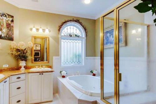 a bathroom with a tub and a shower and a window at Luxury Vacation Estate in Pottstown