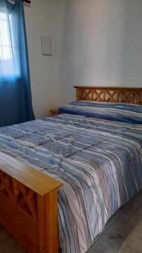 1 dormitorio con 1 cama con marco de madera en Casa Villa Zorzal en Villa Larca