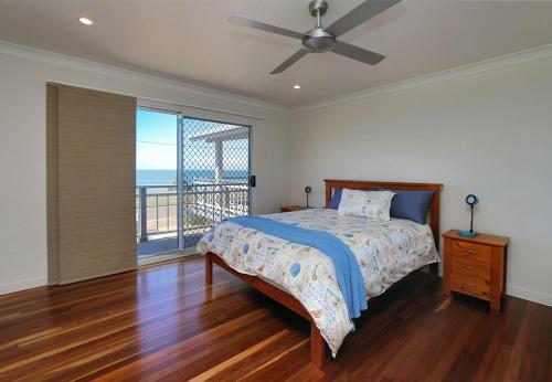1 dormitorio con cama y vistas al océano en 129 Sea Esplanade Burnett Heads, en Burnett Heads