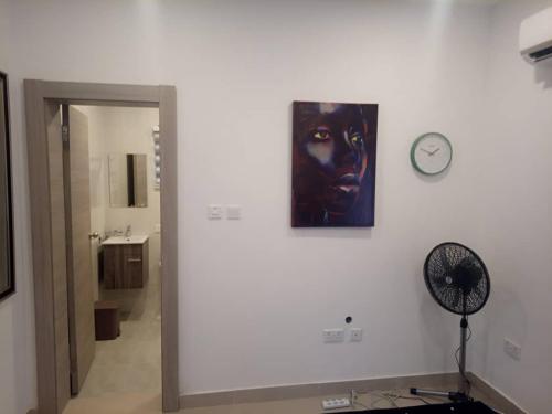 a bathroom with a clock and a mask on the wall at 2 Bedroom Duplex House - 3 Bathrooms, Balcony , Kitchen, Living Room, - 24 7 Security, Gated, Gym, Pool, Wifi, DSTV, in Tema