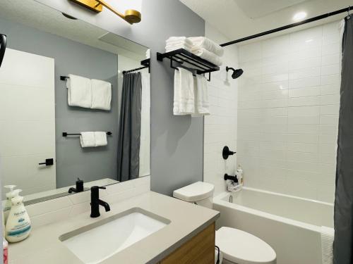 坎莫爾的住宿－Joes Brand New 2 King Bedrooms Townhome in Canmore，浴室配有盥洗盆、卫生间和浴缸。