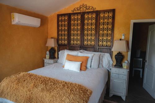 a bedroom with a large bed with an orange headboard at Viña Calabria in Valle de Guadalupe