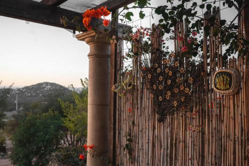 a pole with a bunch of flowers on a fence at Viña Calabria in Valle de Guadalupe