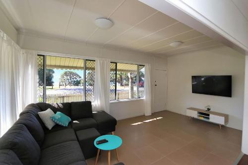 a living room with a couch and a flat screen tv at 115 Esplanade in Bargara