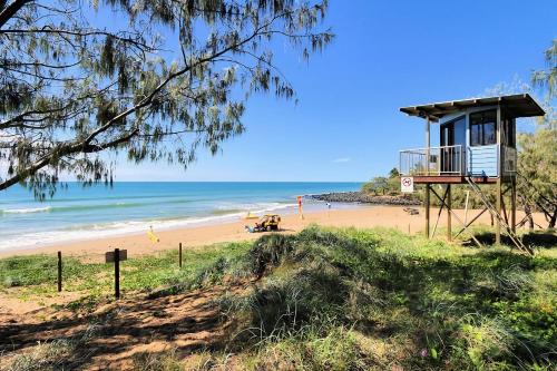 a beach with a lifeguard tower on a beach at 115 Esplanade in Bargara