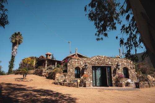 an old stone building in the middle of a field at Viña Calabria in Valle de Guadalupe