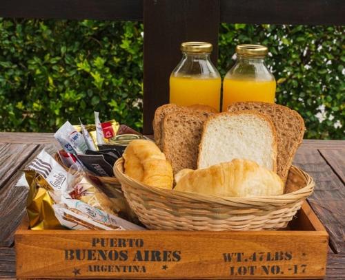 a basket of bread and two bottles of orange juice at Solares de la Bahía in Tigre