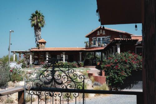 a house with a gate and a palm tree at Viña Calabria in Valle de Guadalupe