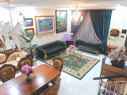 uma sala de estar com sofás e uma mesa num quarto em Semenyih Escapar Villa by Dan em Semenyih