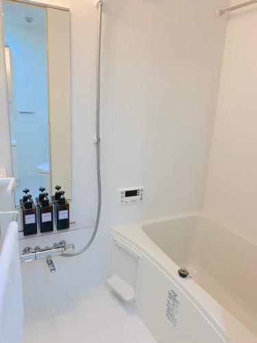 a white bathroom with a sink and a mirror at Ken's Place四谷 in Tokyo