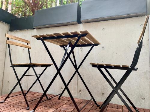 two wooden chairs sitting next to a wall at Ken's Place四谷 in Tokyo