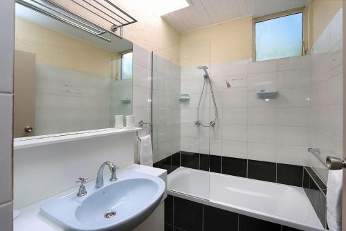 a bathroom with a sink and a bath tub at Beach at your feet in Bargara