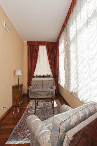 a living room with two couches and a large window at Hotel Villa Pigna in Ascoli Piceno