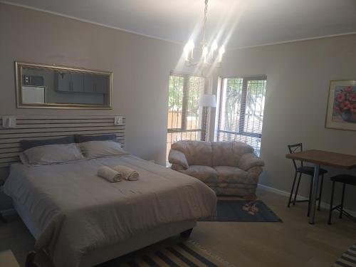 Un dormitorio con una cama, una silla y una mesa. en TERRA NOVA ACCOMMODATION - Unit Julia, en Ciudad del Cabo