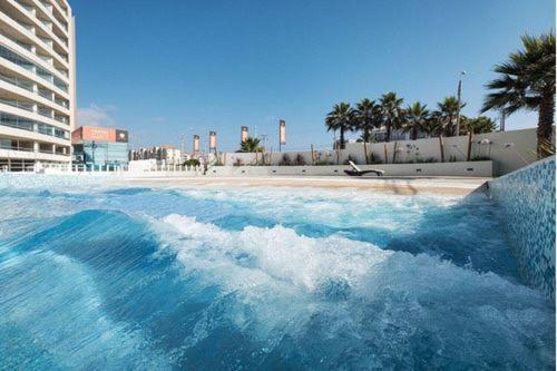 a swimming pool with a wave in the water at Departamento Aqua La Serena in La Serena
