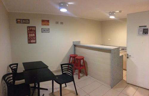 a kitchen with a counter and chairs and a table at Departamento Aqua La Serena in La Serena
