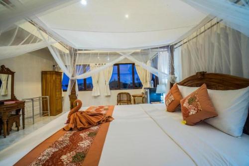 1 dormitorio con 1 cama grande y ventana grande en Bangbang Guest House Ubud, en Ubud