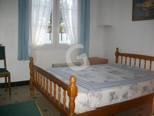1 dormitorio con cama con marco de madera y ventana en Maison La Tranche-sur-Mer, 3 pièces, 5 personnes - FR-1-357-91, en La Tranche-sur-Mer