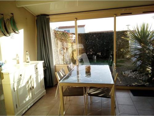 une table et des chaises dans une cuisine avec une fenêtre dans l'établissement Charmant pavillon T3 pour 5 pers. à 500 m de la plage - La Tranche-sur-Mer - FR-1-357-96, à La Tranche-sur-Mer