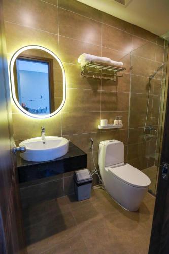 a bathroom with a toilet and a sink and a mirror at The Sol House in Phu Quoc