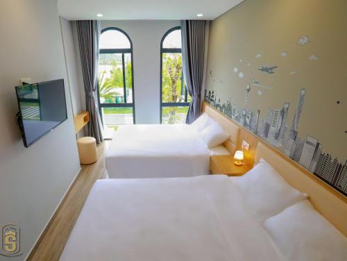 a hotel room with two beds and a window at The Sol House in Phu Quoc