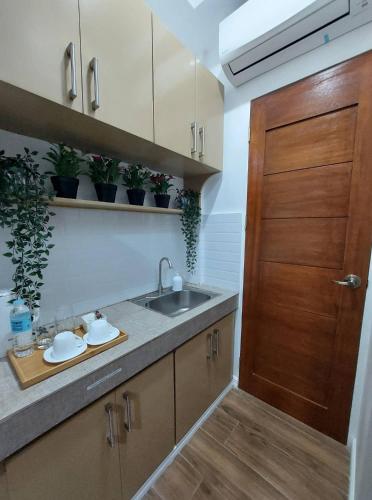 a kitchen with a sink and a wooden door at Regal425 Condotel in Angeles