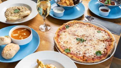 a table with plates of food and a pizza at Holiday Inn Express Aberdeen City Centre by IHG in Aberdeen