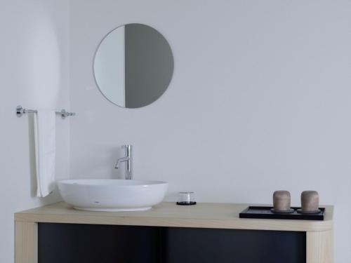 a bathroom with a white sink and a mirror at SOKI Kanazawa in Kanazawa