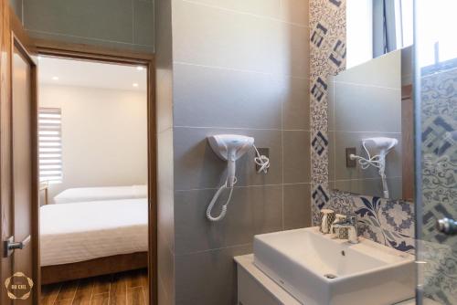 a bathroom with a sink and a mirror at Hotel Du Ciel in Da Lat