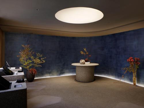 a room with a table and a blue wall at SOKI Kanazawa in Kanazawa
