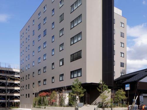 a large white building with trees in front of it at SOKI Kanazawa in Kanazawa