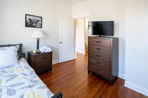 a bedroom with a bed and a television on a dresser at Contemporary 3-Bedroom Home with Balcony in RVA in Richmond