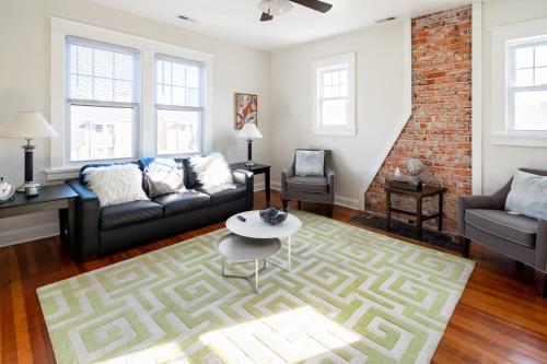 a living room with a couch and a table at Contemporary 3-Bedroom Home with Balcony in RVA in Richmond