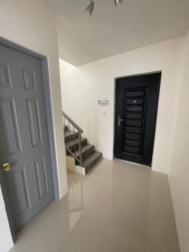 a hallway with a black door and stairs at Casa Castaño Cd Jrz in Ciudad Juárez