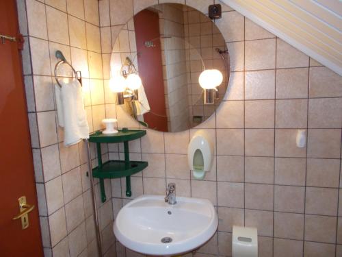 un bagno con lavandino e specchio di Nimród Pihenőház a Egerszalók
