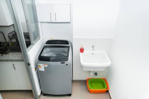 a small bathroom with a sink and a machine at Hermoso departamento de estreno in Lima