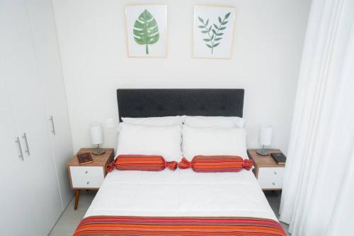 a bedroom with a bed with two pillows on it at Hermoso departamento de estreno in Lima