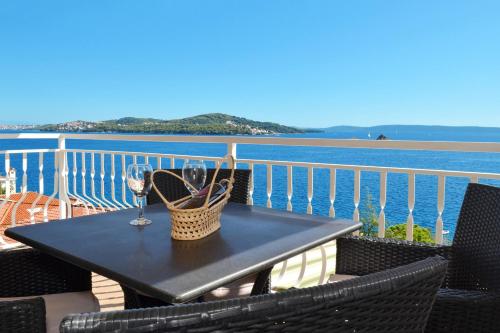 a table with a glass of wine on a balcony at Apartments Inge in Seget Vranjica