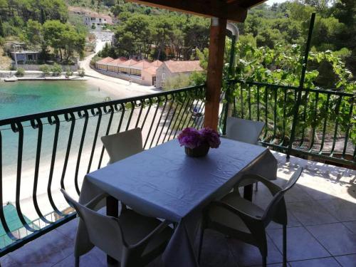 a table with a vase of flowers on a balcony at Apartments Rogac in Rogač