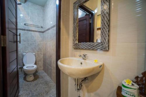 y baño con lavabo, aseo y espejo. en Bangbang Guest House Ubud, en Ubud