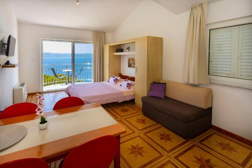 une chambre d'hôtel avec un lit, une table et des chaises dans l'établissement Apartments Dream view, à Brela