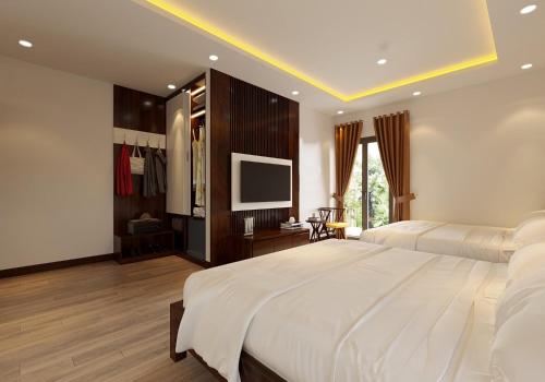 a bedroom with a large white bed and a television at Tamcoc Catalina Hotel in Ninh Binh